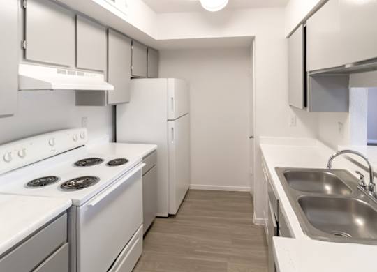 a kitchen with white appliances, a double stainless steel sink, and gray cabinets