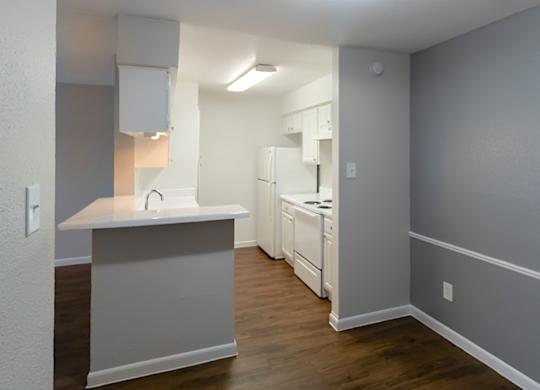 a kitchen with white appliances and cabinets at The Forest Apartments