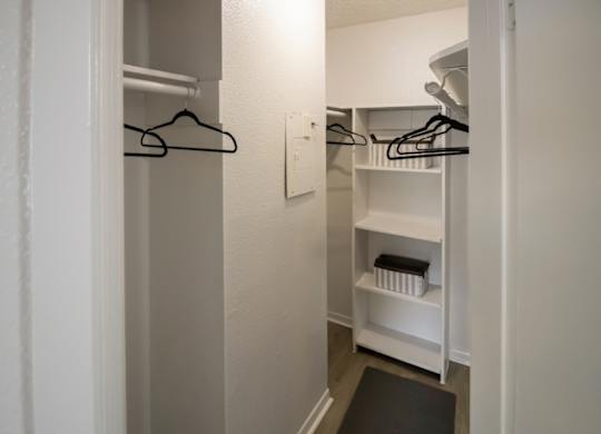 a spacious walk in closet in a Pine Creek Apartment with shelves and hanging bars