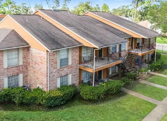 A residential building with lush landscaping and private patios and balconies at The Forest