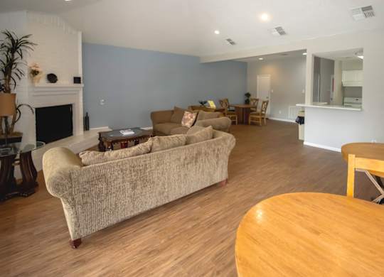 a resident lounge area with couch, fireplace, and kitchen in the Pine Creek clubhouse