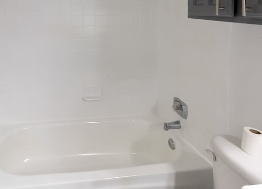a white bathroom with a tub and a toilet