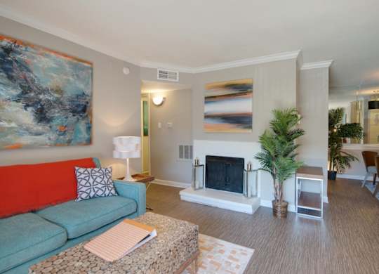 a living room with a fireplace and model furnishings at Hudson at Westchase Apartments
