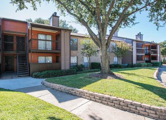 a residential building and lush landscaping at Hudson at Westchase Apartments in Houston