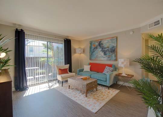 a living room with model furnishings, natural light, and wood-style floors at Hudson at Westchase
