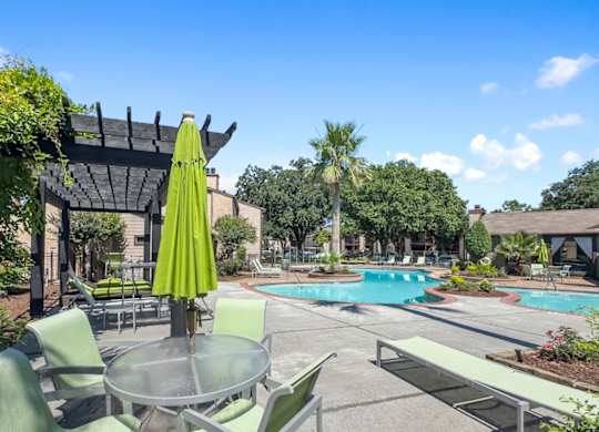a patio with tables and chairs, a pergola, and a swimming pool at Hudson at Westchase