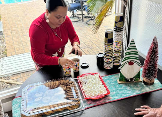 A woman is preparing food on a table with Christmas decorations.