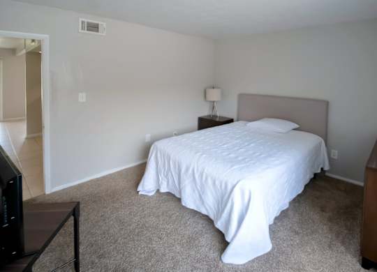 a carpeted bedroom with furnishings in the model at Winford Place Apartments