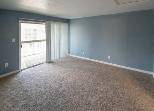 a bedroom with carpeting and sliding glass doors to a private deck at Winford Place