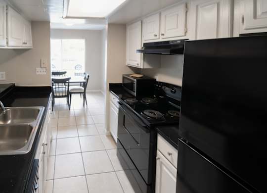a Winford Place kitchen with black appliances and white cabinets