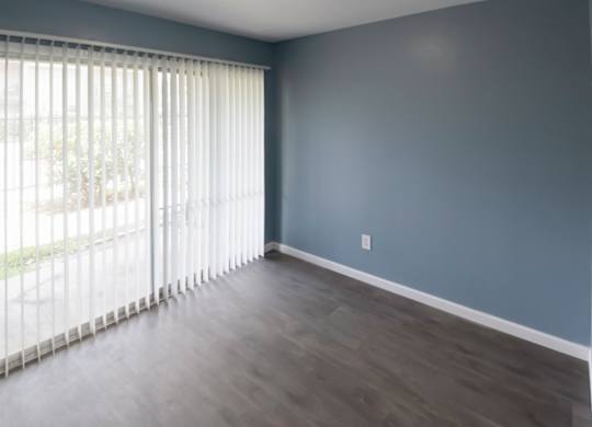 a living room with wood-style flooring and a sliding glass door to a private patio