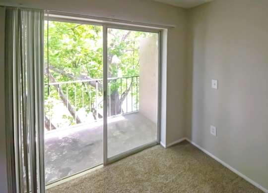 an bedroom with sliding glass doors to a private balcony