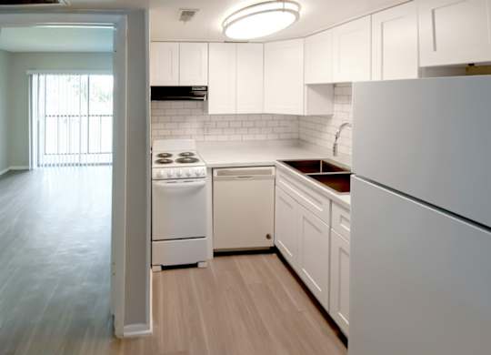 A waterview crossing kitchen with white appliances and white cabinets