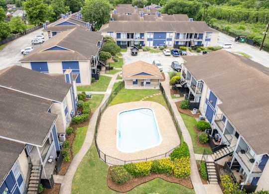 an aerial view of one of the two pools and residences at Pine Creek Apartments
