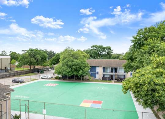 a large outdoor sports court surrounded by trees at Pine Creek Apartments