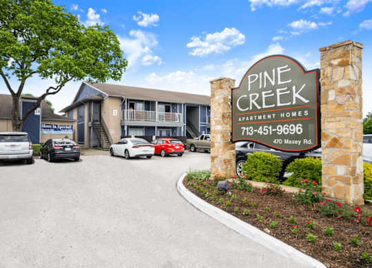 the entrance and monument sign at Pine Creek Apartments for rent in Houston, TX