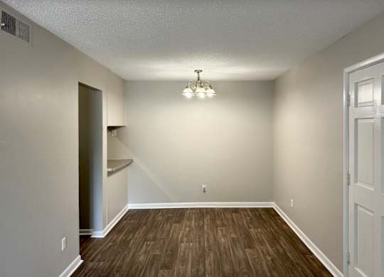an empty living room with wood flooring and white walls at Spring Lake Cove Apartments, Alabama, 35215