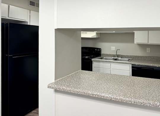 a kitchen with a granite counter top and a black refrigerator at Spring Lake Cove Apartments, Birmingham, AL
