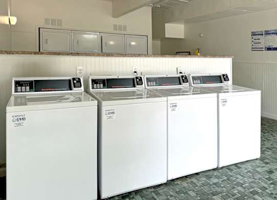 four washers and dryers in a row in a hotel laundry room at Spring Lake Cove Apartments, Alabama, 35215