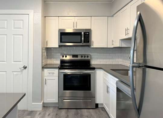 a kitchen with stainless steel appliances and white cabinets at Ascot Place Apartments, Birmingham, AL