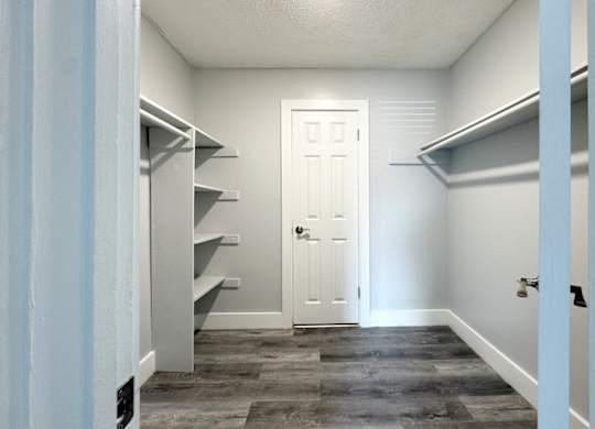 a walk in closet with a white door and a hallway with shelves and a door at Ascot Place Apartments, Birmingham Alabama