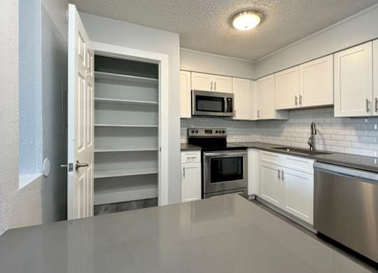a kitchen with white cabinets and stainless steel appliances at Ascot Place Apartments, Birmingham, 35235