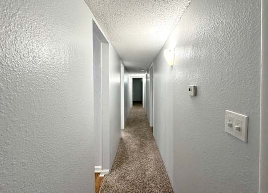 a three bedroom apartment hallway with a carpeted floor and white walls at Ascot Place Apartments, Birmingham