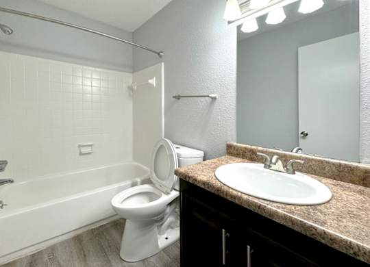a bathroom with a toilet and a sink and a bath tub at Ascot Place Apartments, Alabama