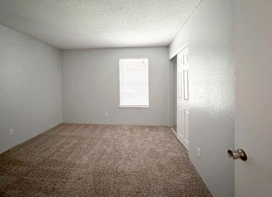 a bedroom with carpet, a closet, and a window at Ascot Place Apartments, Birmingham Alabama