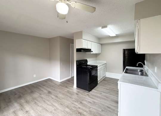 A kitchen with a black oven and white cabinets.