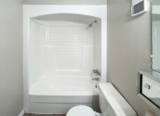 A white bathroom with a toilet, sink, and bathtub.