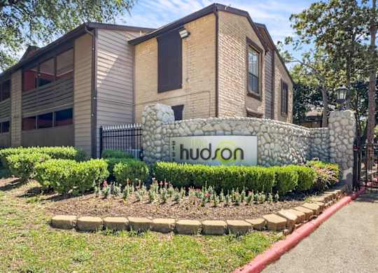 The monument sign at the entrance to Hudson at Westchase Apartments in Houston, TX