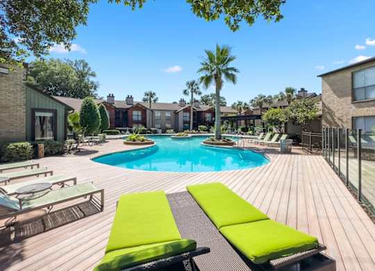 the lush sundeck and pool with lounge chairs at Hudson at Westchase Apartments