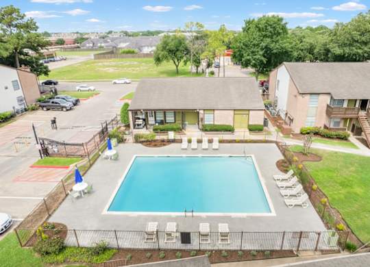 a large swimming pool and sundeck with lounge chairs at Crosby at Westchase Apartments