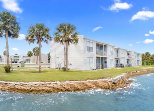 a group of 12th and beach apartments overlooking the water with palm trees