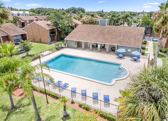 Winford Place offers a sparkling pool with loungers and shaded tables surrounded by lush pallms
