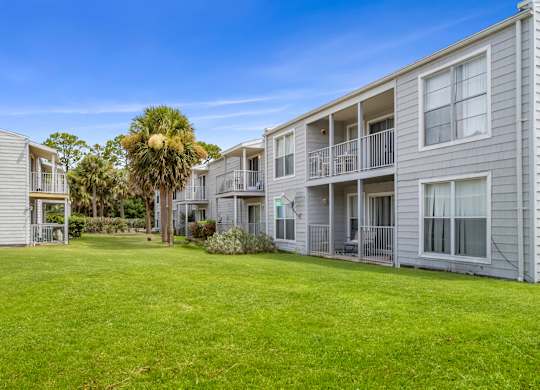 a lush, green courtyard between residential buildings at 12th and beach apartments