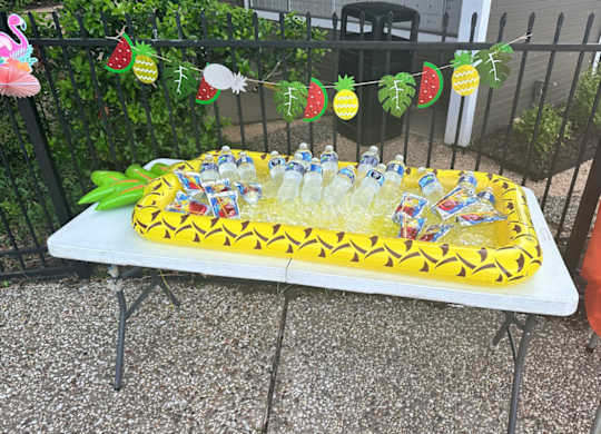 A table with a cake and drinks on it.