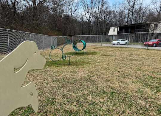 A playground with a slide and a seesaw in a grassy area.