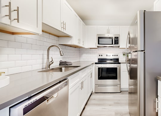 a modern kitchen with stainless steel appliances and white cabinets at Spring Lake Cove Apartments, Birmingham Alabama
