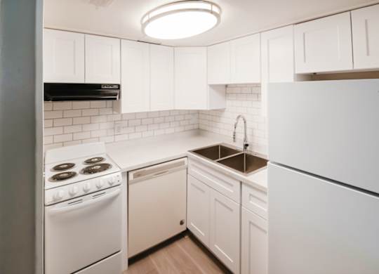 A Waterview Crossing Apartment kitchen with white appliances, tile, and cabinets