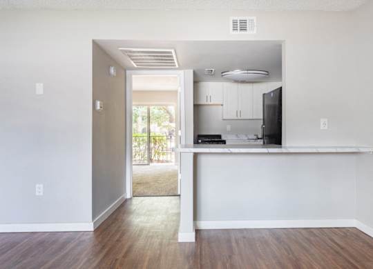 a living room with wood-style flooring and a kitchen with black appliances at Waterview Crossing