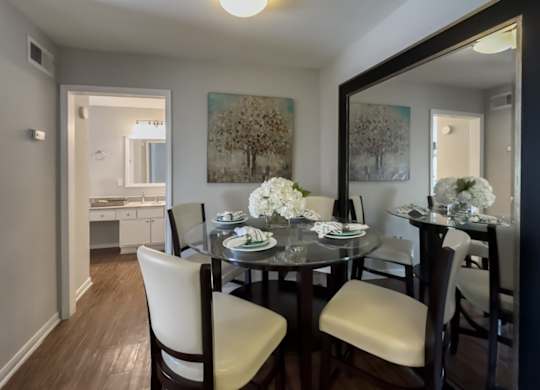 a dining room with overhead lighting and model dining set in a Waters at Westchase Apartments home