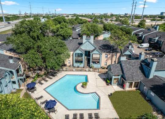 an aerial view of the clubhouse, pool, and residences at Waters at Westchase Apartments in Houston