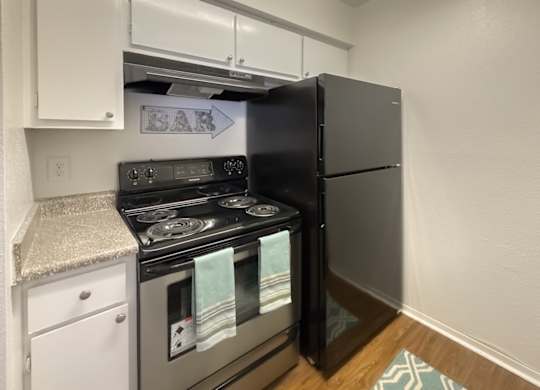 a kitchen with stainless steel appliance stove and a black refrigerator