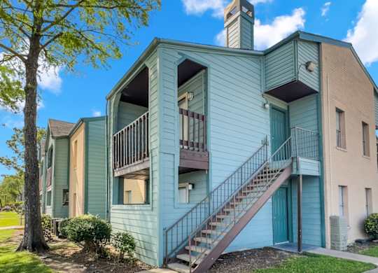 a residential apartment building with stairs at Waters at Westchase apartments in houston