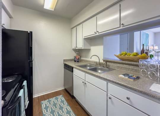 a kitchen with white cabinets and a sink and a refrigerator