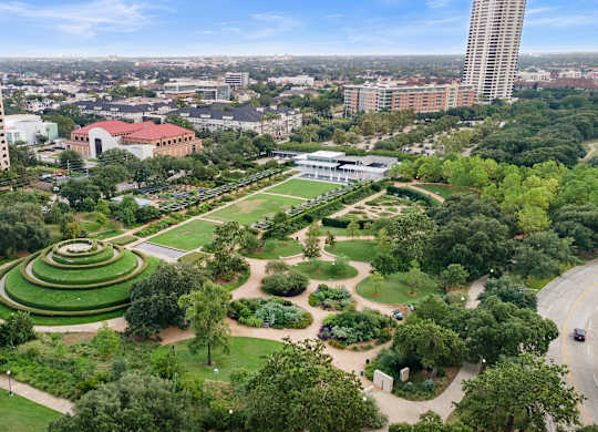 A large green park with a circular garden in the middle.
