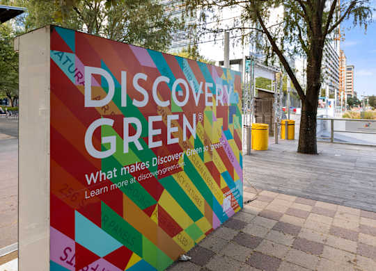 A colorful advertisement for Discover Green is displayed in an outdoor setting.