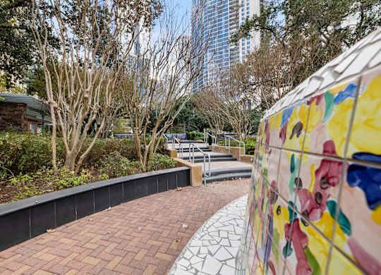 A wall with a mural of flowers is on the right side of a brick path.